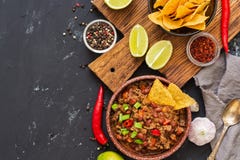 Chili con carne com as microplaquetas dos nachos no fundo rústico Alimento mexicano Lugar para o texto, vista superior fotografia de stock royalty free Chili con carne com as microplaquetas dos nachos no fundo rústico Alimento mexicano Lugar para o texto, vista superior fotografia de stock royalty free