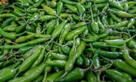 Chillis verdes para a venda empilhada no mercado vegetal fotografia de stock royalty free Chillis verdes para a venda empilhada no mercado vegetal fotografia de stock royalty free