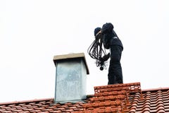 Chimney sweep on roof of home working stock photo Chimney sweep on roof of home working stock photo