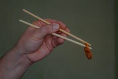 The Chinese chopsticks in a hand stock photo The Chinese chopsticks in a hand stock photo