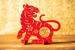A Chinese New Year of tiger 2022 mascot paper cut on a wood table in the morning the Chinese means fortune no logo no trademark
