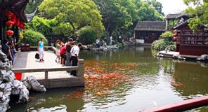 Chinesische Touristen, die Karpfen in einem traditionellen Garten, China einziehen stockbilder Chinesische Touristen, die Karpfen in einem traditionellen Garten, China einziehen stockbilder