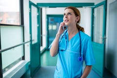 Chirurg die op mobiele telefoon in gang spreken Stock Afbeeldingen