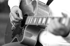 Chitarra enorme nelle mani di un musicista Fotografie Stock Chitarra enorme nelle mani di un musicista Fotografie Stock