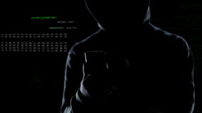 Chiuda su del pirata informatico incappucciato che inizia l'attacco cyber allo smartphone, lanciando la bomba fotografie stock Chiuda su del pirata informatico incappucciato che inizia l'attacco cyber allo smartphone, lanciando la bomba fotografie stock