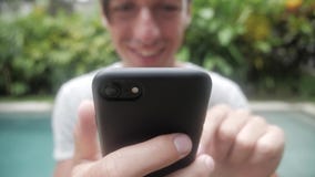 Chiuda su dell'uomo che usando Smartphone all'aperto Giovane con il computer della compressa Un uomo al giardino sulle reti socia stock footage Chiuda su dell'uomo che usando Smartphone all'aperto Giovane con il computer della compressa Un uomo al giardino sulle reti socia stock footage
