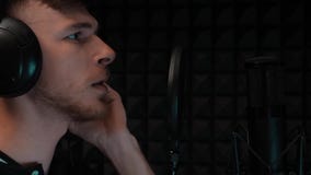 Chiuda su di giovane ragazzo bello che canta la canzone emozionale Canto drammatico allo studio vocale professionale Ripetizione stock footage Chiuda su di giovane ragazzo bello che canta la canzone emozionale Canto drammatico allo studio vocale professionale Ripetizione stock footage