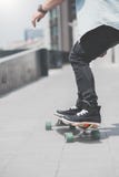 Chiuda su di skater& x27; gambe di s sulla guida di longboard alla via dentro all'aperto immagini stock libere da diritti Chiuda su di skater& x27; gambe di s sulla guida di longboard alla via dentro all'aperto immagini stock libere da diritti