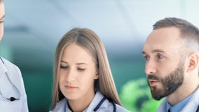 Chiuda sul fronte dello specialista europeo della donna e dell'uomo medico animatamente che discute qualcosa archivi video Chiuda sul fronte dello specialista europeo della donna e dell'uomo medico animatamente che discute qualcosa archivi video