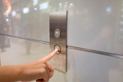 Chiuda sul torchio tipografico manuale di waman un bottone alto dell'elevatore dentro la costruzione per il pavimento ad alto liv immagini stock libere da diritti Chiuda sul torchio tipografico manuale di waman un bottone alto dell'elevatore dentro la costruzione per il pavimento ad alto liv immagini stock libere da diritti