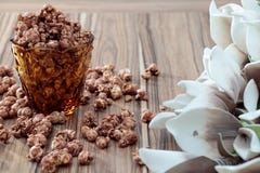 Chocolate aroma popcorn in the yellow glass and on the brown wood table with white flower background. Chocolate aroma popcorn in yellow glass and on the brown Stock Photo Chocolate aroma popcorn in the yellow glass and on the brown wood table with white flower background. Chocolate aroma popcorn in yellow glass and on the brown Stock Photo