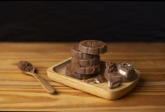 Chocolate colocado em uma colher de madeira do assoalho de madeira de madeira da placa imagem de stock Chocolate colocado em uma colher de madeira do assoalho de madeira de madeira da placa imagem de stock