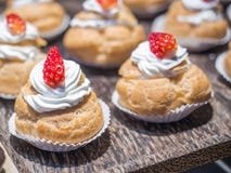 Fresh cream puffs filled with whipped cream and strawberry on top. stock image Fresh cream puffs filled with whipped cream and strawberry on top. stock image