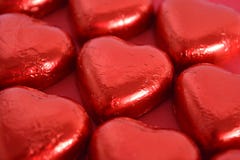 Chocolates en forma de corazón en fondo rojo imagen de archivo Chocolates en forma de corazón en fondo rojo imagen de archivo