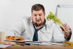 choix de poids excessif réfléchi d'homme d'affaires sain ou nourriture industrielle sur le lieu de travail photographie stock libre de droits choix de poids excessif réfléchi d'homme d'affaires sain ou nourriture industrielle sur le lieu de travail photographie stock libre de droits