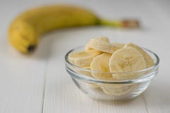 Chopped pieces of banana in a glass bowl on a wooden table. royalty free stock photography Chopped pieces of banana in a glass bowl on a wooden table. royalty free stock photography