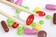 Chopsticks Keep A Bright Red Pill Royalty Free Stock Photos