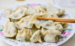 Chopsticks Pick Up Boilded Chineses Dumplings From A Plate. Royalty Free Stock Photos Chopsticks Pick Up Boilded Chineses Dumplings From A Plate. Royalty Free Stock Photos