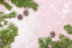 Christmas background, green pine branches, cones decorated with snow on snowy pink background. Creative composition with border stock photo Christmas background, green pine branches, cones decorated with snow on snowy pink background. Creative composition with border stock photo