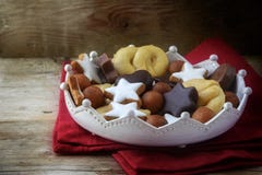 Christmas cookies and sweets like homemade cinnamon stars, marzipan balls, chocolate and biscuit in a pottery crown bowl on a red royalty free stock image Christmas cookies and sweets like homemade cinnamon stars, marzipan balls, chocolate and biscuit in a pottery crown bowl on a red royalty free stock image