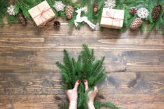 Christmas creative frame composition. Female hand holding spruce branch for making. on the wooden background. royalty free stock photography Christmas creative frame composition. Female hand holding spruce branch for making. on the wooden background. royalty free stock photography