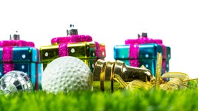 Christmas gift box and golf ball on grass