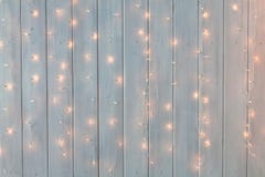 Christmas Lights Burning On A White Wooden Background. New Year Back. Stock Photos Christmas Lights Burning On A White Wooden Background. New Year Back. Stock Photos