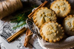 Christmas mince pies in a wicker basket on vintage linen cloth with cinnamon sticks and fir tree branches royalty free stock photography Christmas mince pies in a wicker basket on vintage linen cloth with cinnamon sticks and fir tree branches royalty free stock photography