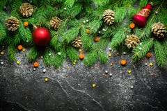 Christmas and New Year background. Christmas tree branch on a black background. Cones and fur-tree toys. View from above. Stock Image Christmas and New Year background. Christmas tree branch on a black background. Cones and fur-tree toys. View from above. Stock Image
