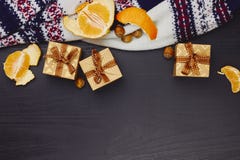 Christmas, New Year or winter holidays composition. Craft gift boxes with ribbon, tangerines, hazelnuts and warm knitted sweater stock images Christmas, New Year or winter holidays composition. Craft gift boxes with ribbon, tangerines, hazelnuts and warm knitted sweater stock images