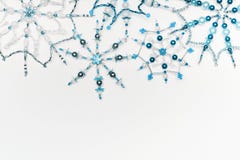 Christmas Or Winter Concept. Border Of Various Handmade Blue Snowflakes Made From Beads And Bugle On White Desk Background, Top Vi Stock Photo