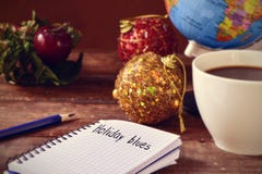 Christmas ornaments, cup of coffee, globe and text holidays blue royalty free stock images Christmas ornaments, cup of coffee, globe and text holidays blue royalty free stock images