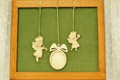 Christmas panel. Vintage wooden figurines of angels with pipe and star and wooden Christmas tree toy on green background in brown stock photos Christmas panel. Vintage wooden figurines of angels with pipe and star and wooden Christmas tree toy on green background in brown stock photos