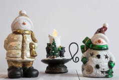 Christmas toy snowman on a light background with decorative candles. Christmas horizontal composition. Christmas decorations. New royalty free stock photo Christmas toy snowman on a light background with decorative candles. Christmas horizontal composition. Christmas decorations. New royalty free stock photo