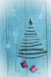 Christmas tree made from dry sticks on wooden, blue background. Snow flaks image. Christmas tree ornament, craft, gifts royalty free stock image Christmas tree made from dry sticks on wooden, blue background. Snow flaks image. Christmas tree ornament, craft, gifts royalty free stock image