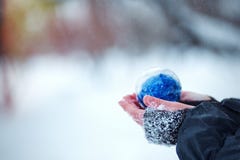 Christmas tree toy in the hands of child. Round blue Christmas ball on snow background. royalty free stock photo Christmas tree toy in the hands of child. Round blue Christmas ball on snow background. royalty free stock photo