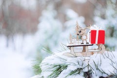 Christmas winter holiday greeting card. Wooden cute reindeer on sled, red gift boxes on white snow and green christmas trees outd stock photo Christmas winter holiday greeting card. Wooden cute reindeer on sled, red gift boxes on white snow and green christmas trees outd stock photo