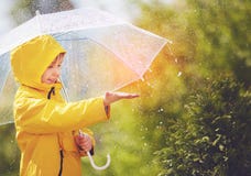A chuva de travamento da criança feliz deixa cair no parque da mola Imagem de Stock A chuva de travamento da criança feliz deixa cair no parque da mola Imagem de Stock