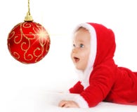 Chéri de Noël regardant une bille rouge de pétillement photographie stock libre de droits Chéri de Noël regardant une bille rouge de pétillement photographie stock libre de droits