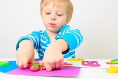 Chłopiec bawić się z glinianym ciastem, edukacją i daycare, obrazy stock Chłopiec bawić się z glinianym ciastem, edukacją i daycare, obrazy stock