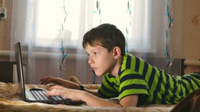 Chłopiec laptop wyszukuje internet bawić się kłamać w łóżku zbiory wideo Chłopiec laptop wyszukuje internet bawić się kłamać w łóżku zbiory wideo