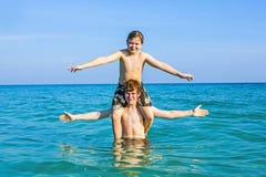 Chłopiec ma zabawę bawić się Piggyback w ciepłym oceanie obraz stock Chłopiec ma zabawę bawić się Piggyback w ciepłym oceanie obraz stock