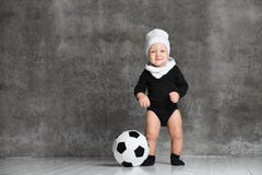 Chłopiec spojrzenia zaskakujący na boku, blisko czarny i biały futbolu w jego iść na piechotę być ubranym białego bawełnianego ka zdjęcie royalty free Chłopiec spojrzenia zaskakujący na boku, blisko czarny i biały futbolu w jego iść na piechotę być ubranym białego bawełnianego ka zdjęcie royalty free