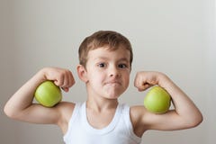 Chłopiec z jabłka przedstawienia bicepsami obraz royalty free Chłopiec z jabłka przedstawienia bicepsami obraz royalty free