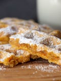 Cialda tagliata della carota spolverata con lo zucchero a velo su un bordo di legno su un fondo scuro fotografia stock Cialda tagliata della carota spolverata con lo zucchero a velo su un bordo di legno su un fondo scuro fotografia stock