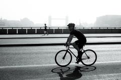 Ciclista e pareggiatore sul ponte di Londra, Londra, Regno Unito fotografia stock libera da diritti Ciclista e pareggiatore sul ponte di Londra, Londra, Regno Unito fotografia stock libera da diritti