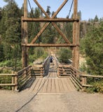 Ciclista que camina a través de puente colgante imagen de archivo libre de regalías Ciclista que camina a través de puente colgante imagen de archivo libre de regalías