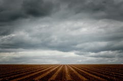 Ciel dramatique au-dessus d'un champ sillonné photo libre de droits Ciel dramatique au-dessus d'un champ sillonné photo libre de droits