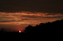 Ciel rouge de coucher du soleil avec le soleil au-dessus de l'horizon Images stock Ciel rouge de coucher du soleil avec le soleil au-dessus de l'horizon Images stock
