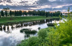 Cielo drammatico di tramonto sopra il fiume di Tvertsa e le sue rive pittoresche dopo la tempesta Città provinciale russa Toržok, Fotografie Stock Cielo drammatico di tramonto sopra il fiume di Tvertsa e le sue rive pittoresche dopo la tempesta Città provinciale russa Toržok, Fotografie Stock